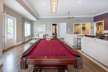 A pool table is in the middle of a room with a fan and a couch at Foxwood Apartments, Raleigh-Durham, NC, 27616